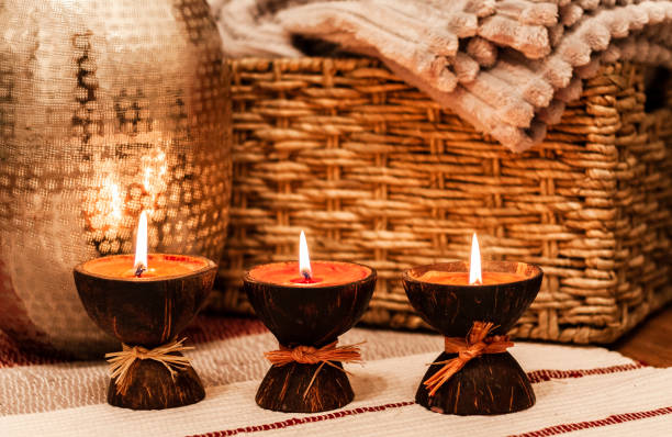istock Cozy home interior decor, burning candles on a multi-colored rug on the background of a wicker straw box - Image. 1086633886