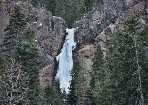 istock Large frozen waterfall in a serene forest in winter 1086648370