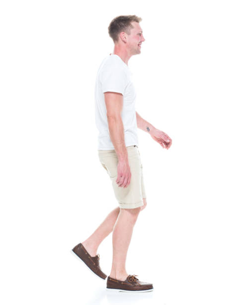 istock Handsome man in shirt and shorts is walking, side view 1086649218