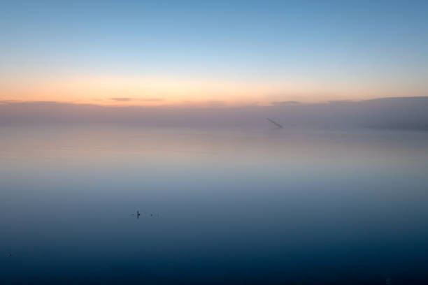 istock fog on a lake at sunrise with a pole in the background 1086652262