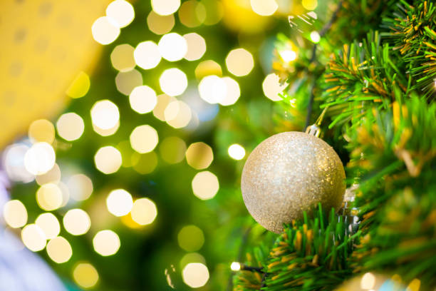 istock Glittering Baubles with Glowing Sparkling Gold defocused Light (bokeh) Illumination background with decorated Christmas Tree. Special Holidays, Festival design decoration, New Year Celebration, Party. 1086663666