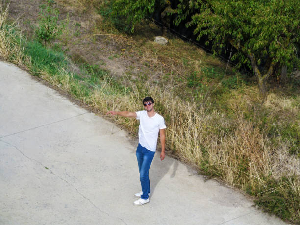 istock Alone hitchhiking man on the road raised his hand to stop auto 1086665156
