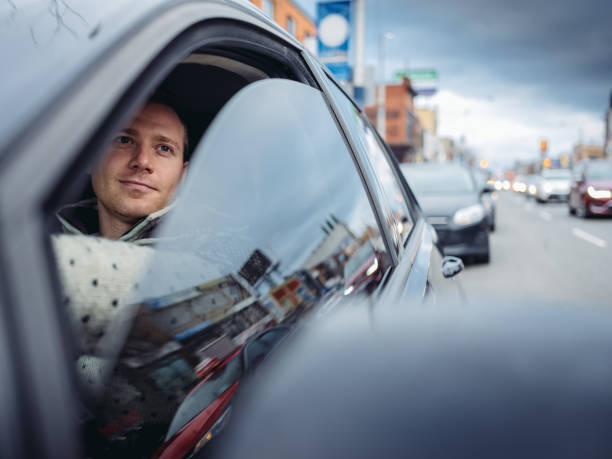 istock Millennial man using phone in a car in winter 1086665190