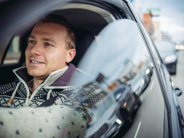 Millennial man driving in a car in winter