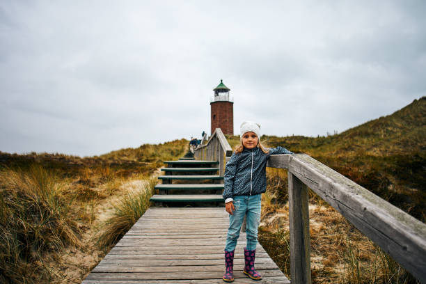 dziewczynka pozuje przed latarnią morską - lighthouse vacation zdjęcia i obrazy z banku zdjęć