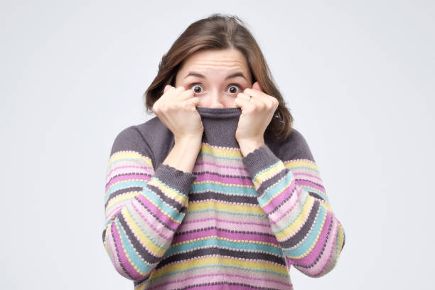 istock Girl pulling her trendy sweater over head having fun being childish disappearing in her clothes 1086671182