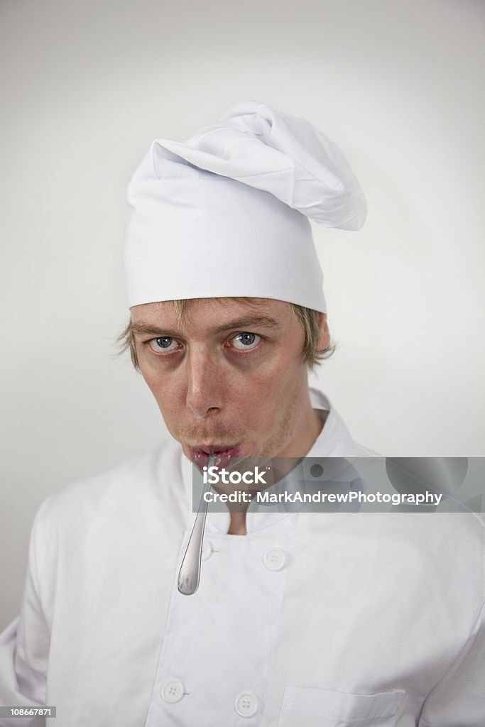 Crazy Chefkoch mit Spoon in Mouth - Lizenzfrei Arbeit und Beschäftigung Stock-Foto