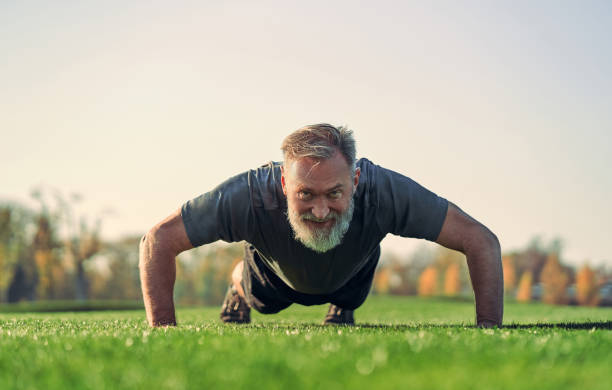 The old sportsman pushing up on the grass The old sportsman pushing up on the grass senior bodybuilders stock pictures, royalty-free photos & images
