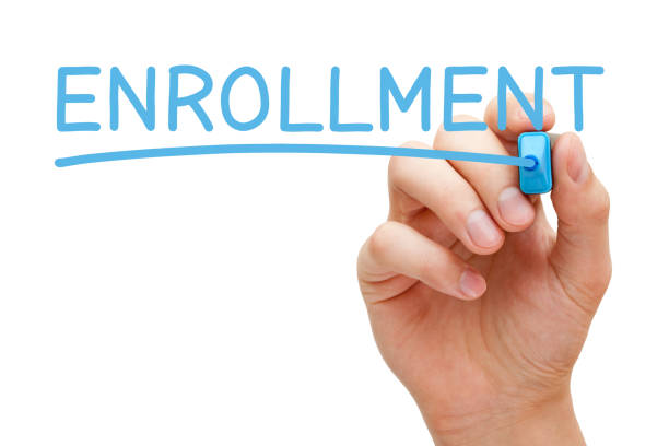 Enrollment Handwritten With Blue Marker Hand writing the word Enrollment with blue marker on transparent wipe board isolated on white. enrollment stock pictures, royalty-free photos & images