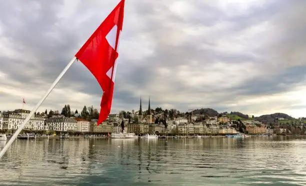 View of lake lucern switzerland with swiss flag at the foreground