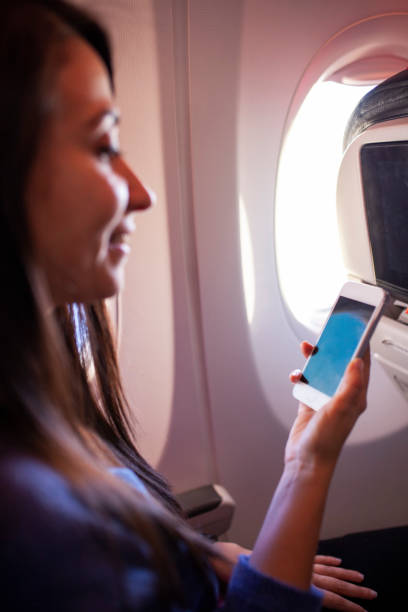 istock Woman using a smart phone on airplane 1086693212