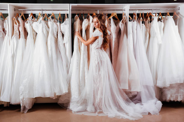 belle mariée cherche sur une robe de mariée élégante - wedding bride buying caucasian photos et images de collection