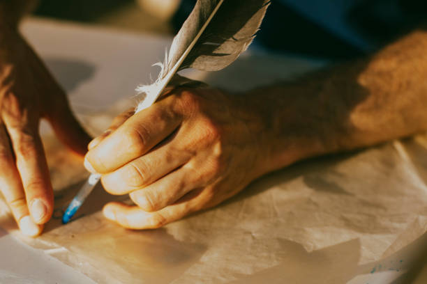 istock Human hands write a bird pen, ancient way of writing 1086704310