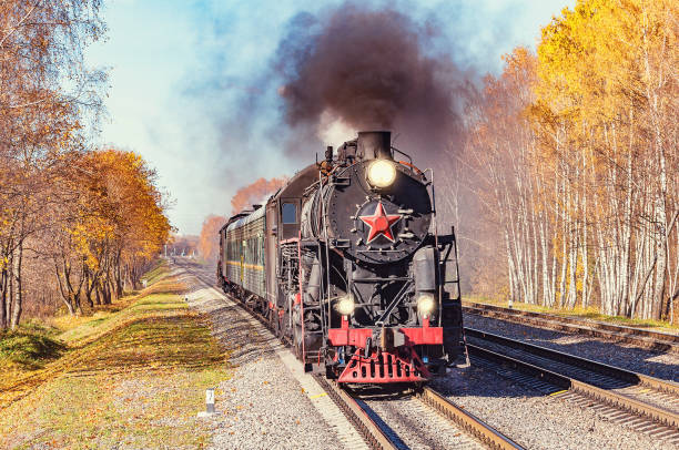 istock Steam train moves toward at autumn day time. 1086706168