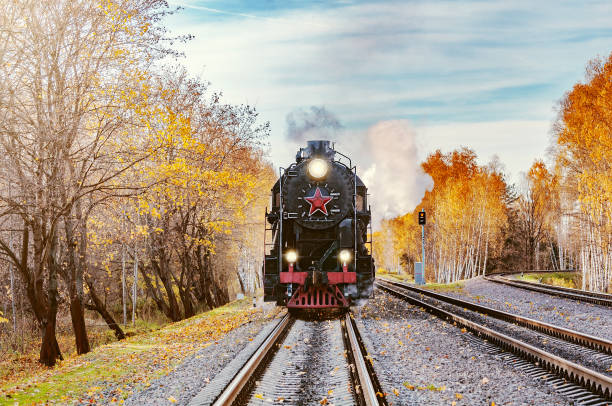 istock Steam train moves toward at autumn day time. 1086706184