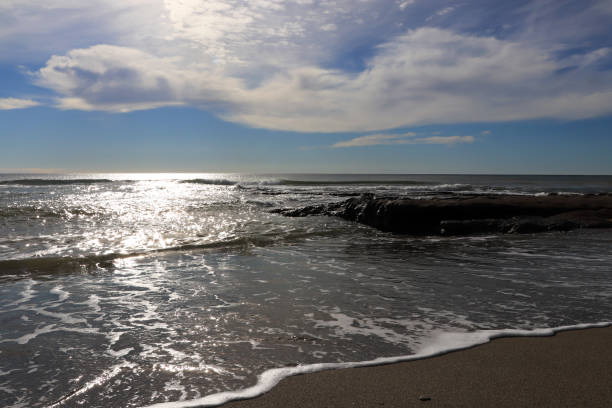 Rock shoreline in the sea with sunlight seascape.