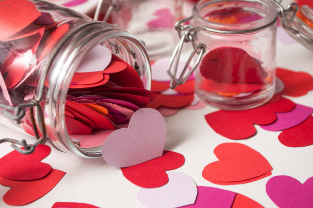 istock paper heart falling from glass container on white background - valentine's day concept 1086718648