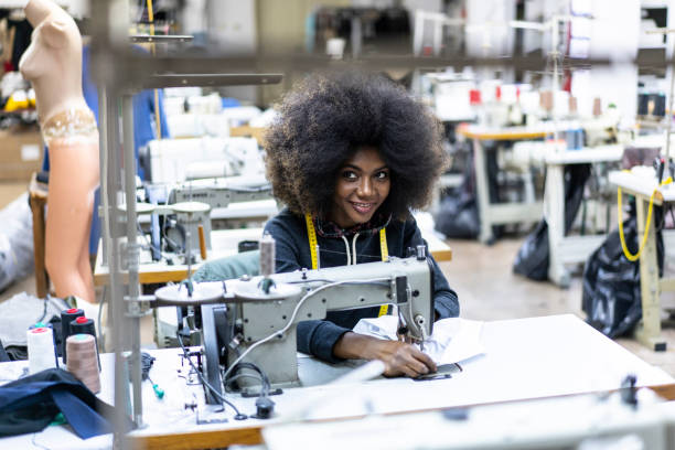 istock Female manual worker using sewing machine in factory 1086725386