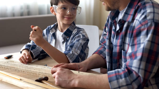 istock Smart attentive boy working with screwdriver and wood, father teaching son 1086726392