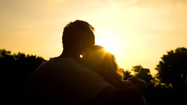 istock Silhouette of old hugging couple, watching sunset together, secure old age 1086727794