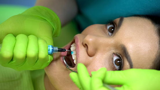 Estomatólogo, aplicación de gel azul en dental, odontología cosmética, estética photo