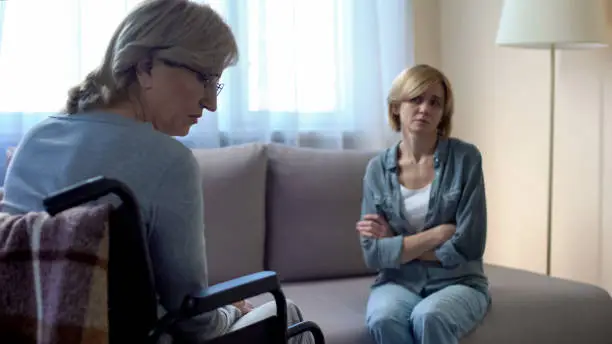 Mother and daughter talking in hospital, misunderstanding, family conflict