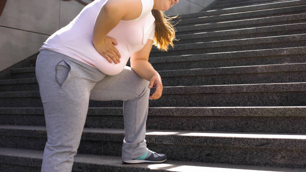 la ragazza grassa sente dolore allo stomaco, il sovrappeso causa problemi di salute, mal di schiena - fat foto e immagini stock