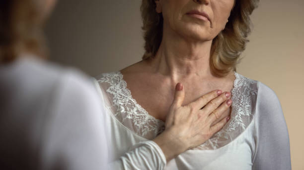 istock Mature female touching her wrinkled neck in front of mirror, aging process 1086728746