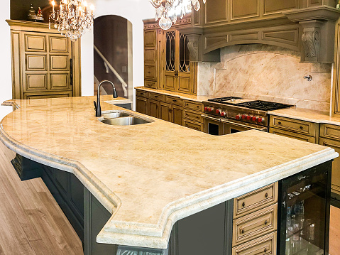 Beautiful Kitchen in Luxury Home with large island, pendant lights, range, and hood. Cabinets and Island are made of wood