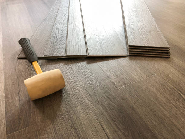 istock Luxury vinyl plank laminate flooring concept. Worker preparing for new floor installation with the tools 1086734498