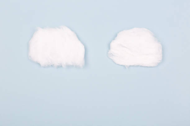Two clouds made from cotton wool Two clouds made from cotton wool on blue background. Flat-lay, top view. Copy space for text. cotton cloud stock pictures, royalty-free photos & images