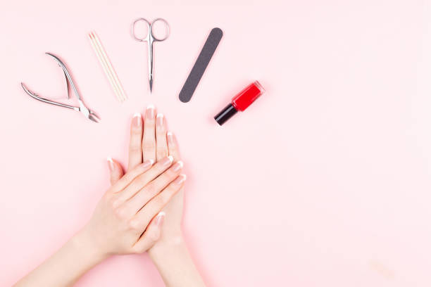 French manicure on pink background French manicure. Beautiful woman hands and manicure tools on pink background. Hands and nails care concept. Flat-lay, top view. Copy space for text or design. cuticle photos stock pictures, royalty-free photos & images
