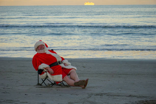 Santa Claus Cocoa Beach Digging feet in the sand and kicking back to rest on Cocoa Beach. It's 5 o'clock somewhere according to Santa florida christmas stock pictures, royalty-free photos & images