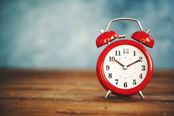 istock Bright red alarm clock on wooden table 1086759000