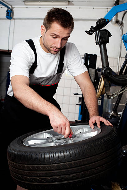 istock Mechanic fixing tyre in car service 108676272