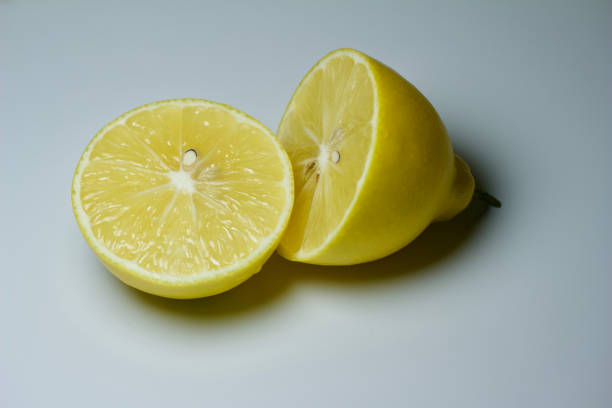 istock Close-up view of a single halved Meyer lemon fruit with plain background 1086776870