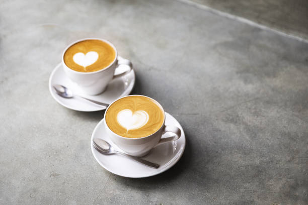 due tazze bianche di gustoso cappucino con amore art latte. il concetto di san valentino. - morning coffee coffee cup two objects foto e immagini stock