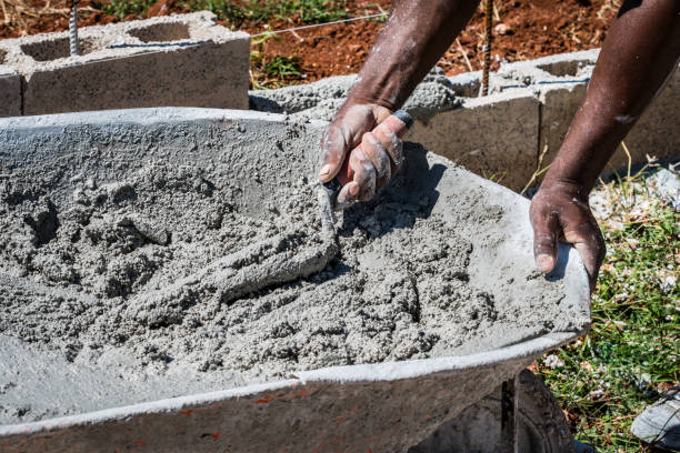 mason schöpfen nassen zement aus schubkarre - mason brick bricklayer installing stock-fotos und bilder