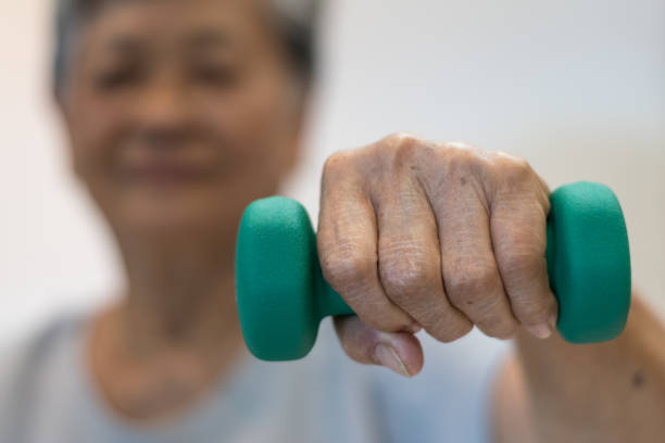 senior ältere asia frau hand halten hantel in physiotherapie sitzung. gesundes altes konzept. - 40 weeks stock-fotos und bilder