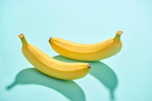istock Fresh ripe fruit bananas, yellow color isolated on blue background 1086803424