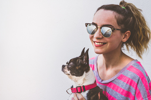 Photograph of a young modern smiling woman with her dog in a casual attitude