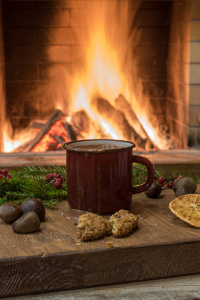 istock Cozy scene before fireplace with enameled mug of hot chocolate, mulled fruit and nuts. 1086808560