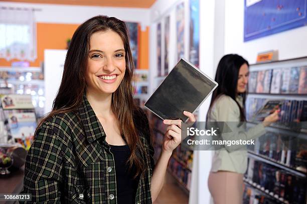 Tienda De Vídeo Joven Mujer Sosteniendo Un Reproductor De Dvd Foto de stock y más banco de imágenes de Tienda de vídeo