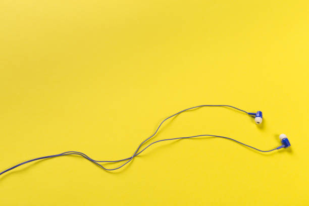 istock black earphones on colour background, top view 1086813092