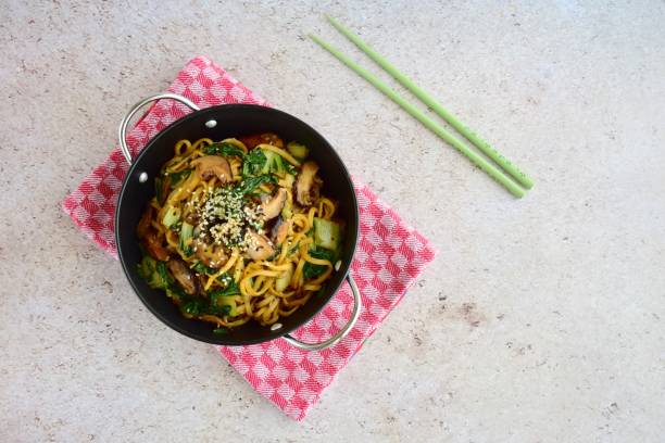 istock Stir-fried egg noodles with shiitake mushroom and bok choy garnish with white and black sesame seeds 1086814968