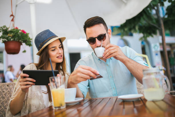 istock Beautiful couple having coffee on a date, using digital tablet and credit card for online shopping 1086817908