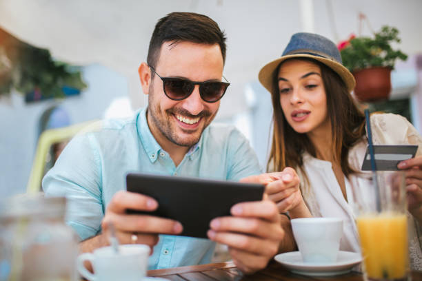 istock Beautiful couple having coffee on a date, using digital tablet and credit card for online shopping 1086820618