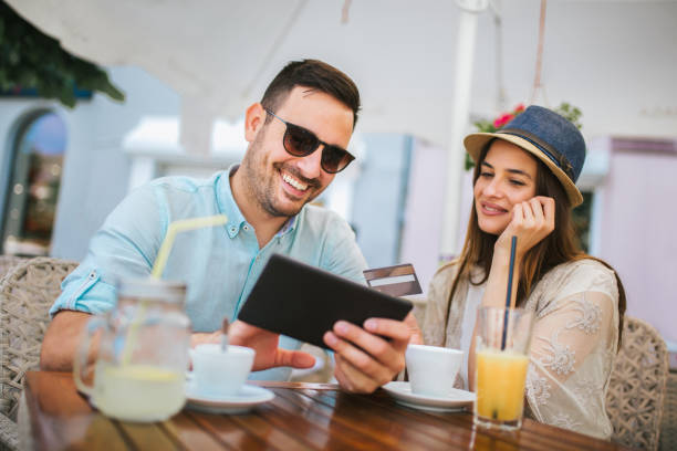 istock Beautiful couple having coffee on a date, using digital tablet and credit card for online shopping 1086820744