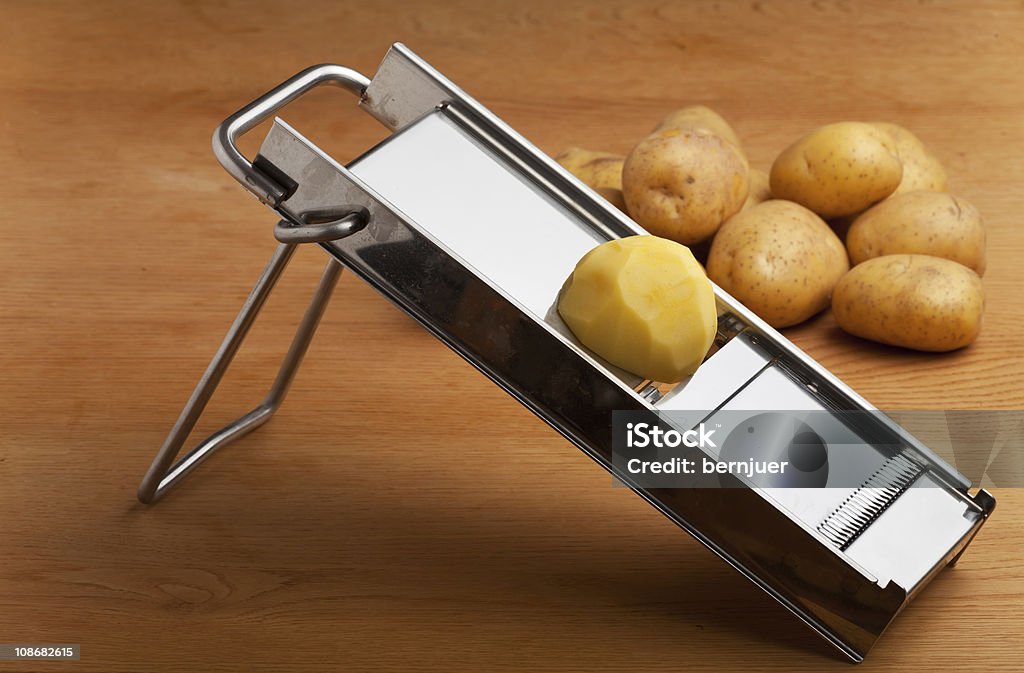Stainless Steel Mandolin With Half A Peeled Potato On Top Stock