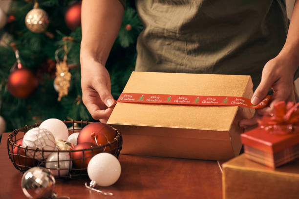 istock Preparing for Christmas holidays. Male hands wrapping gift box 1086827464